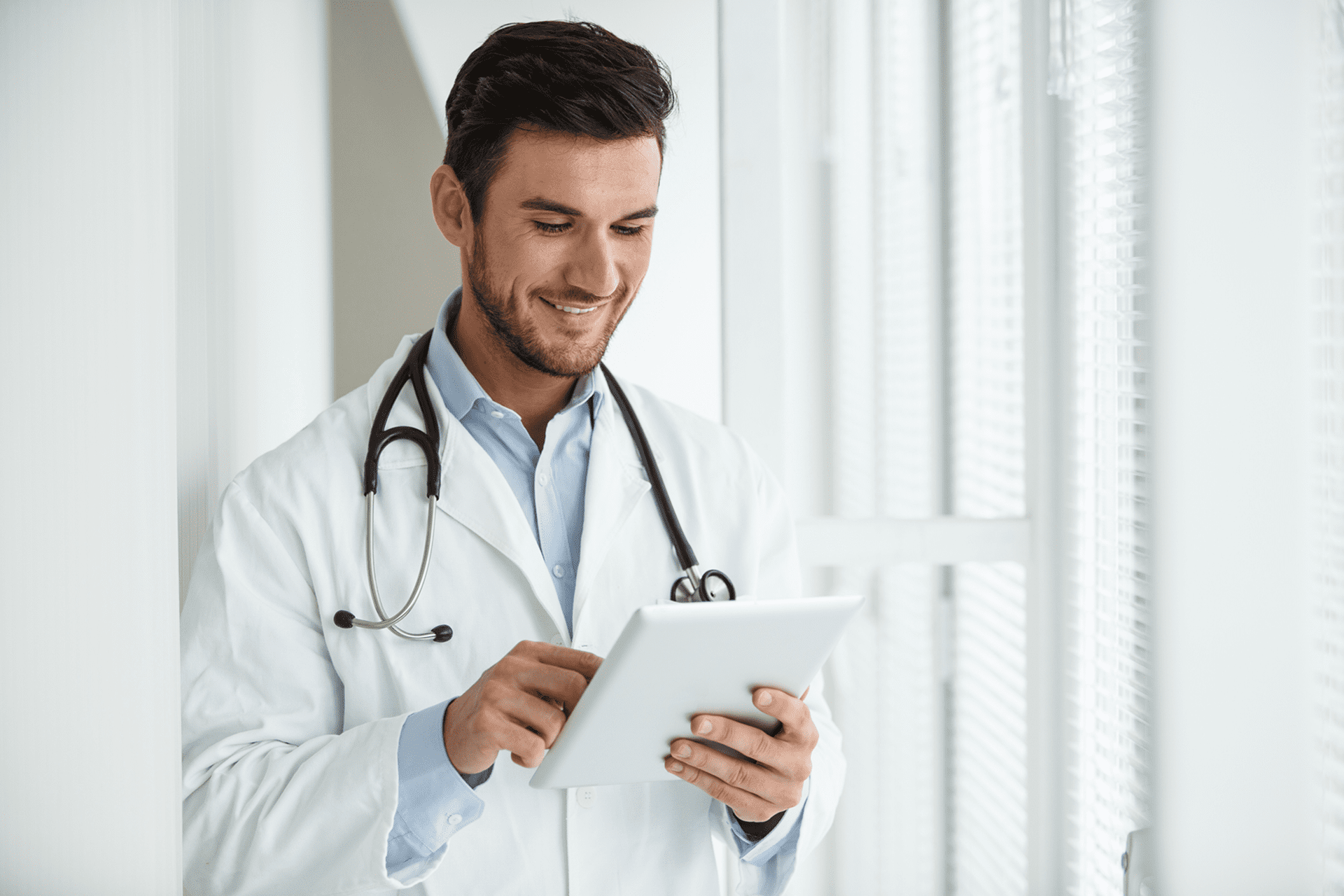 Smiling doctor checking data on tablet